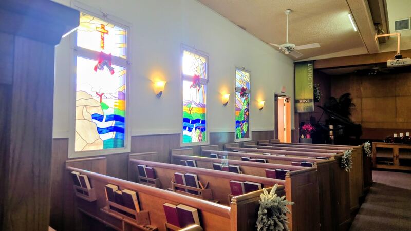 Inside the church: wooden pews and stained glass windows